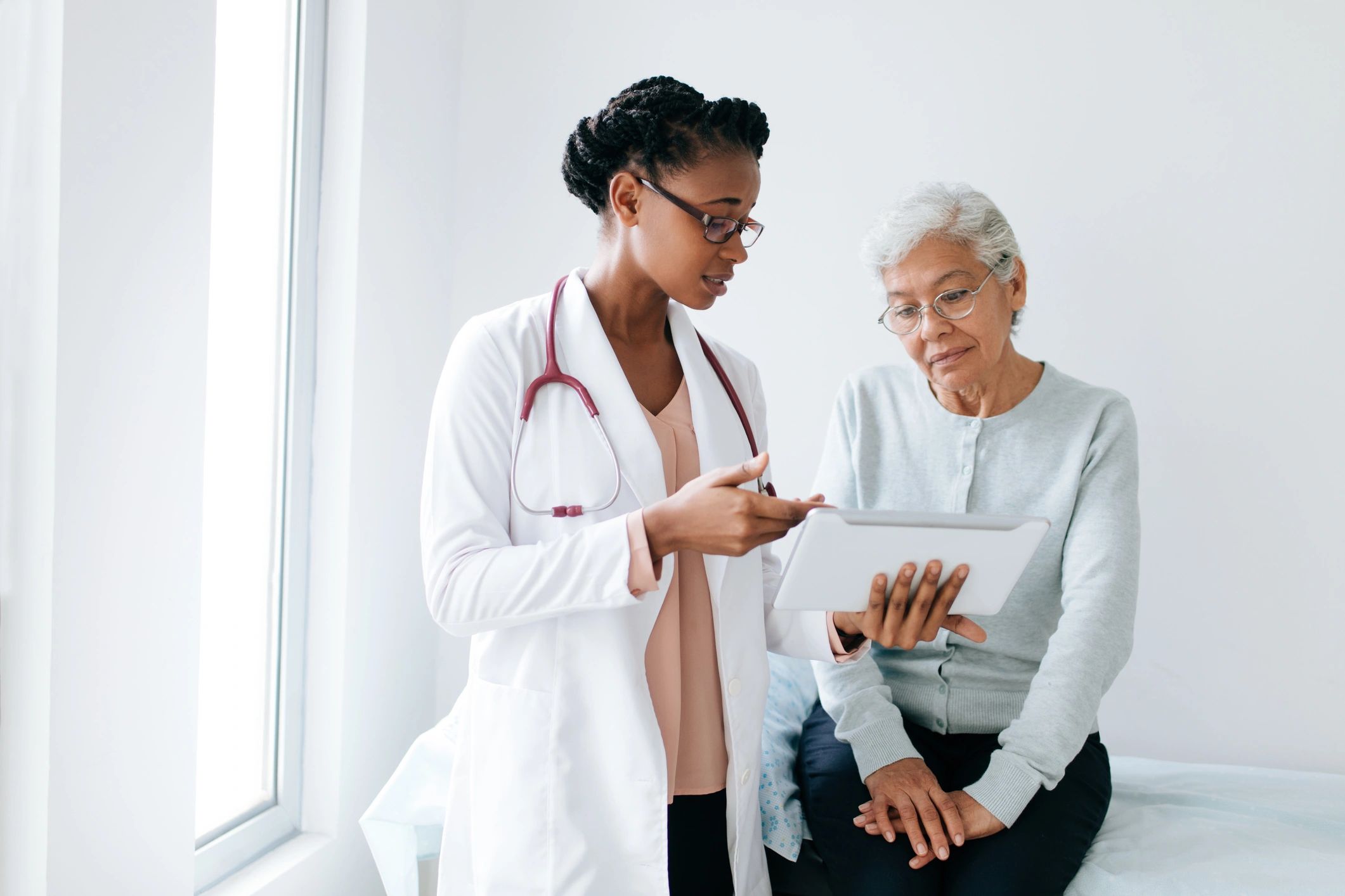 Doctor reviewing treatment information with a patient on a tablet