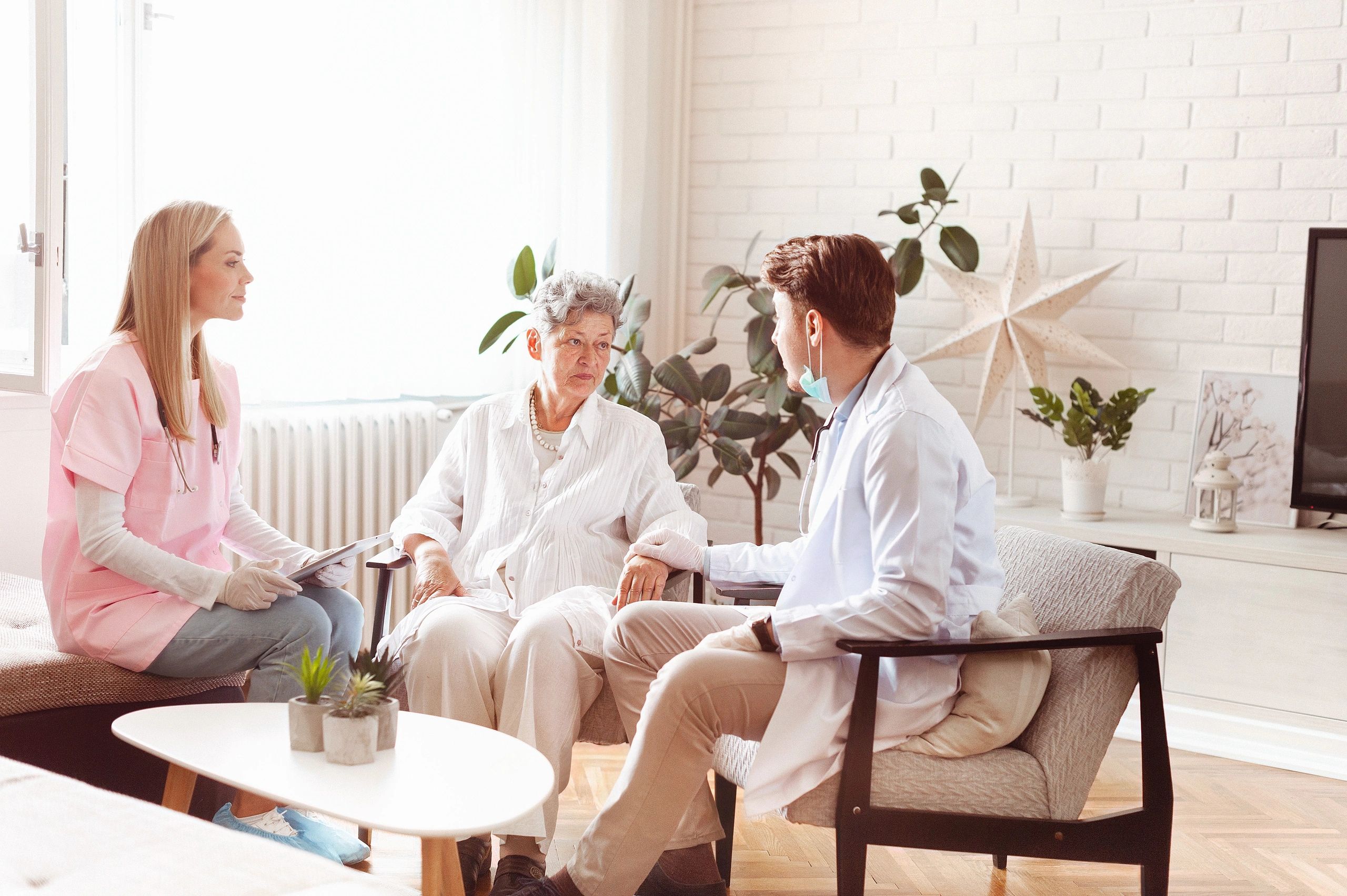 Clinician visiting and supporting an older patient during a wellness consultation