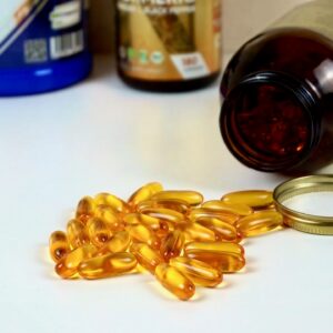 Omega-3 fish oil capsules spilling from supplement bottle